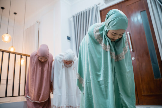 Asian Muslim women in muslim clothes with hijab doing ruku prayer movements during congregational prayers