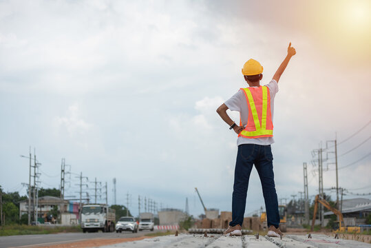 Asian engineers wearing hard hat and safety vest standing with their thumbs up on a construction site can signify that a project is on track and progressing well