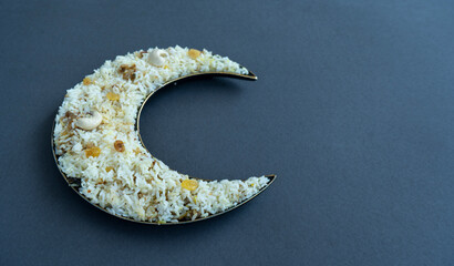 Iftar food arranged on crescent moon shape plate with copy space, Ramadan Kareem background