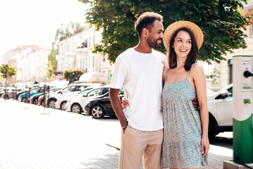 Smiling beautiful woman and her handsome boyfriend. Woman in casual summer clothes. Happy cheerful family. Female having fun. Sexy couple posing in the street at sunny day. In hat