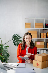 Startup small business SME, Entrepreneur owner woman using smartphone or tablet taking receive and checking online purchase shopping order