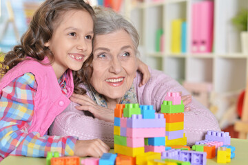 Cute girl and grandmother playing