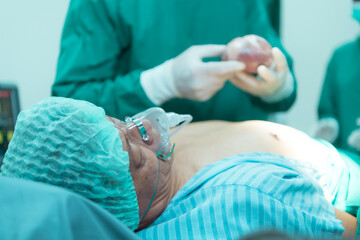 Professor of medicine in cardiology and a team of doctors in the operating room undergoing heart...