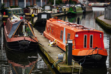 Fototapeta na wymiar Orange house boat, Birmingham canals, housing estate