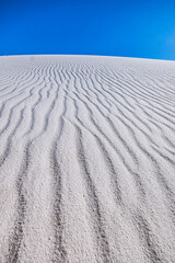 Fototapeta na wymiar Vibrant blue sky and white sand ripples in New Mexico
