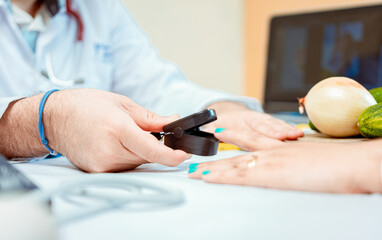 Hand of nutritionist using oximeter on finger of female patient. Close up of hands of nutritionist...