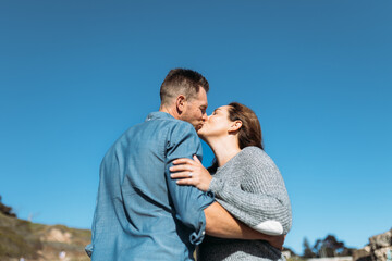 Obraz premium Parents Kissing at the Beach on a Sunny Day