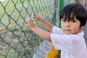 Mexican innocent child looking at camera outdoors, children's da