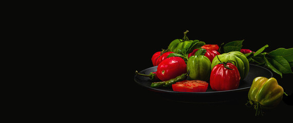 Green and red ribbed tomatoes, American or Florentine variety. Ripe vegetables, fresh bay leaves