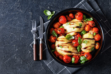 caprese chicken in black baking dish, top view