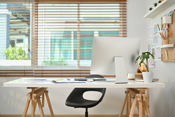 Modern workplace with computer monitor, wireframe, sketches of mobile application on screen, document and supplies on white table