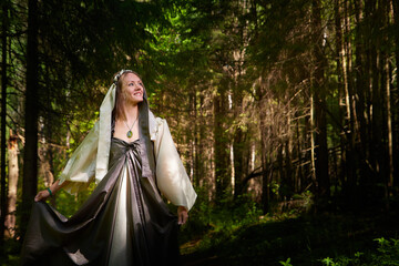 Naklejka premium Beautiful seductive dryad. Pagan spirit of the forest. Portrait of beautiful dryad. Fairy who loves nature in beautiful green summer forest. Concept of environmental friendliness and caring for nature