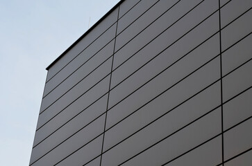 cladding of a building with a expanded metal lattice structure. galvanized gray nets protect the...
