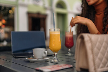 Freshly squeezed orange juice and red juice, with a cup of coffee on the table in the cafe.