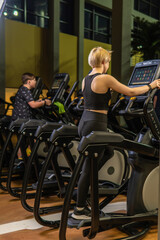 Fototapeta na wymiar Elliptical trainer young woman health, from fit gym from home recreation sportswear, screen elliptical. Enter club living, fitness