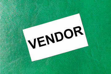 White business card with the text VENDOR on a dark green background