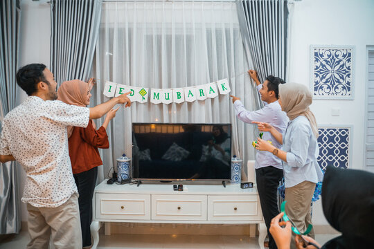 young people put up DIY flag chains for eid mubarak celebration at home