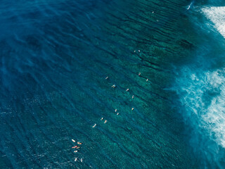 Aerial view of transparent ocean with surfers. Surfing spot in tropical island