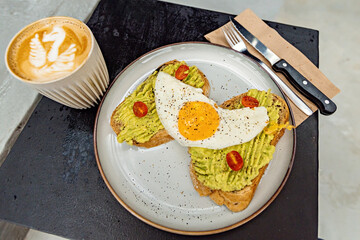 Classical breakfast close up toasts with avocado and sunny side egg