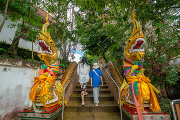 The mother and daughter are walking past the Naga statue stair at Wat Phraphutthabat Si Roi, Chiang...
