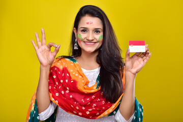 young woman celebrating holi and showing credit card