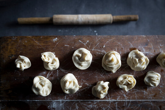 Vegetable dumplings await the steamer with a rolling pin.