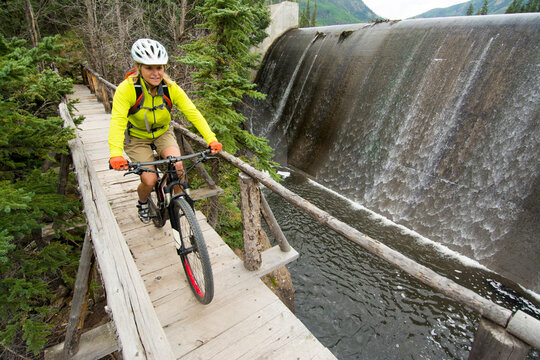 A woman mountain biking below spillway near Wagon Wheel Gap, Creede, Colorado.