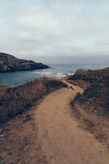Cliffs surrounding the Beach of Antuerta in Ajo, Trasmiera, Cantabria, Spain. The coast is traversed by a hiking trail that runs through stunning scenery.