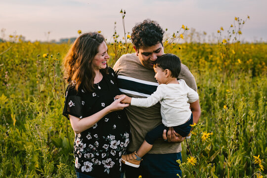 Love and togetherness of multiracial family in outdoor flower field
