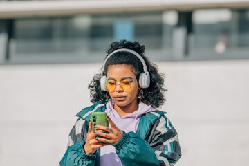 Fototapeta na wymiar girl with headphones on the street with mobile phone