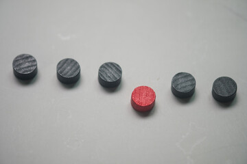 Single red block among black blocks in a row. The symbol for finding the right person for a job. Different opinion, directions, idea, innovation concept. Toxic people