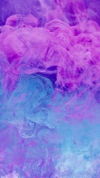 Vertical video. Ink water. Paint splash. Color explosion. Neon pink blue smoke cloud burst mix floating motion abstract art background shot on RED.