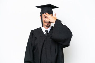 Young university graduate man isolated on white background covering eyes by hands and smiling