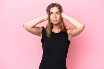 Young caucasian woman isolated on pink background frustrated and covering ears