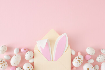 Easter concept. Top view photo of open beige envelope with easter bunny ears pink white eggs on isolated pastel pink background with copyspace