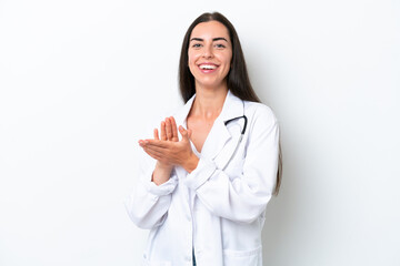 Young caucasian woman isolated on white background wearing a doctor gown and applauding