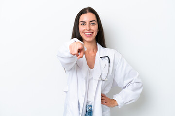 Young caucasian woman isolated on white background wearing a doctor gown and pointing to the front