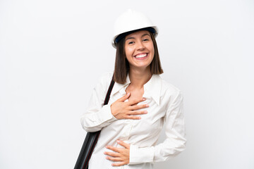 Young architect woman with helmet and holding blueprints isolated on white background smiling a lot