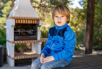 Child boy exploring nature in the forest. Little boy travel in the sunny woodland.