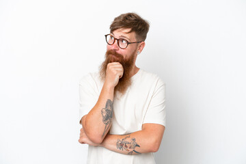 Redhead man with long beard isolated on white background thinking an idea while looking up