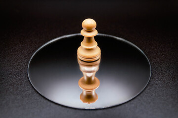 Thinking. Mirror reflection of a pawn to a queen. Chess pieces artistic concept. Thoughts representation