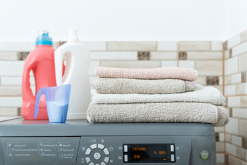 Household chemicals for washing in bottles on the Washing machine and Stack of dry clean towels ....