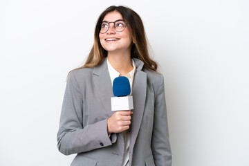 Young caucasian TV presenter woman isolated on white background thinking an idea while looking up