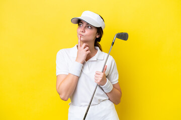 young caucasian woman playing golf isolated on yellow background having doubts while looking up