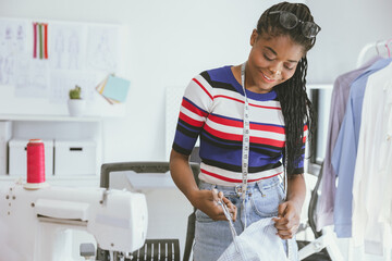 Happy african black woman costume artist tailor clothes designer happy working in clothing studio