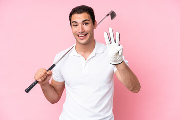 Young golfer player man isolated on pink background happy and counting three with fingers