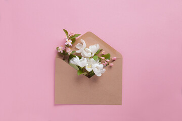 Craft envelope full of spring white fruit flowers flat lay