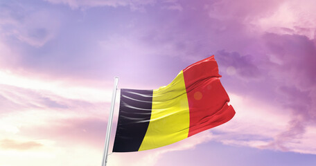 Waving Flag of Belgium in Blue Sky. The symbol of the state on wavy cotton fabric.