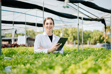 Researcher in white uniform are checking with ph strips in hydroponic farm and pH level scale...