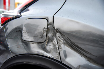Silver car after the accident, broken door, fender and fuel tank close-up. Car accident close-up. A...